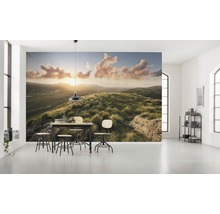 Lichte kamer met fotobehang van een heuvellandschap bij zonsopgang en een eettafelgroep