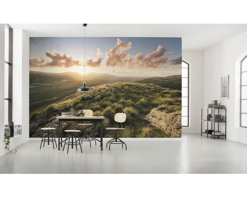 Lichte kamer met fotobehang van een heuvellandschap bij zonsopgang en een eettafelgroep