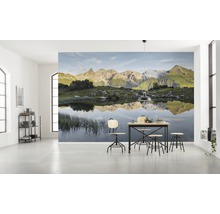 Lichte kamer met fotobehang berglandschap en eettafel met stoelen
