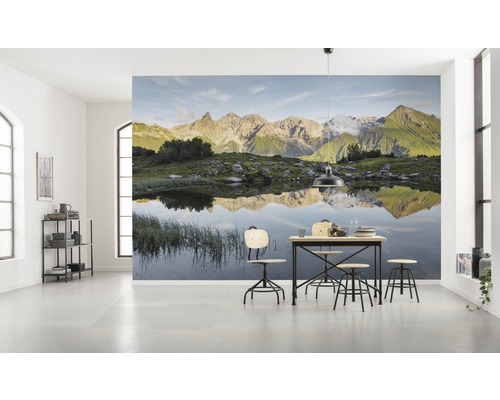 Lichte kamer met fotobehang berglandschap en eettafel met stoelen