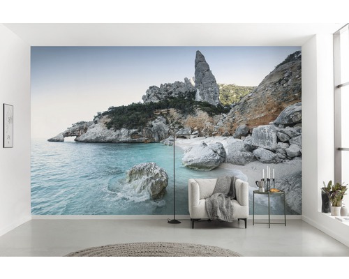 Woonkamer met fotobehang van een rotskust, dat een heldere, ruimtelijke sfeer creëert