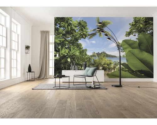 Woonkamer met fotobehang van een tropisch strand, stoel en staande lamp