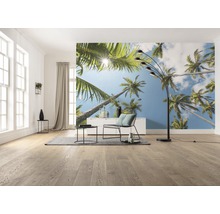 Woonkamer met fotobehang met palmmotief, staande lamp, fauteuil en tafel