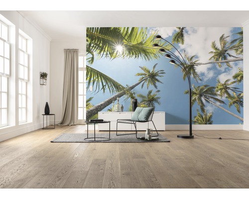 Woonkamer met fotobehang met palmmotief, staande lamp, fauteuil en tafel