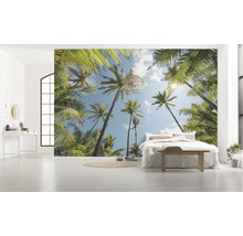 Lichte kamer met fotobehang met palmmotief, bed en decoratie