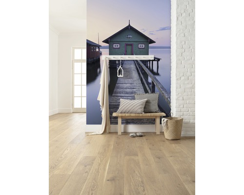 Interieur met houten vloer, bank en fotobehang met zeehuis motief
