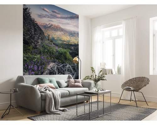 Lichte woonkamer met bank, tapijt en fotobehang met bergmotief