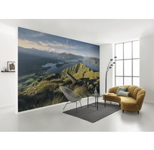 Woonkamer met fotobehang berglandschap, bank, stoel en vloerkleed