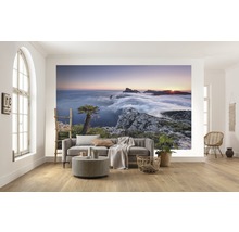 Woonkamer met fotobehang van een berglandschap bij zonsopgang boven de wolken