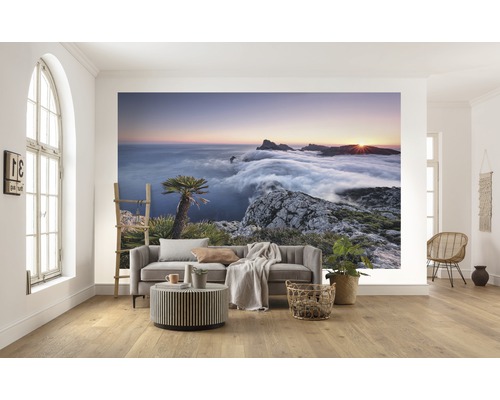 Woonkamer met fotobehang van een berglandschap bij zonsopgang boven de wolken