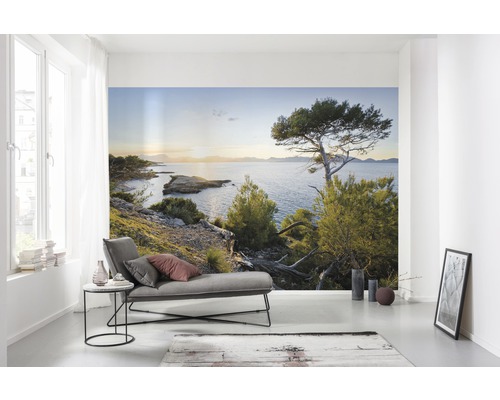 Woonkamer met fotobehang van een kustlandschap met uitzicht op zee.