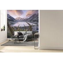 Woonkamer met fotobehang van een berglandschap met meer en bank.
