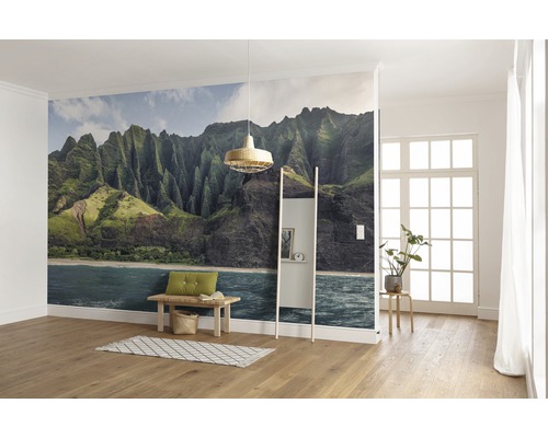 Woonkamer met bergbehang, bank, ladderkast en houten vloer