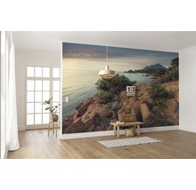 Wanddecoratie met fotobehang van een kustlandschap in een lichte kamer.