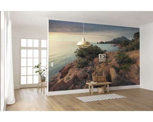 Wanddecoratie met fotobehang van een kustlandschap in een lichte kamer.