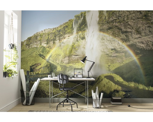 Woonkamer met fotobehang met een waterval en een regenboog, plus bureau en kantoormeubilair.