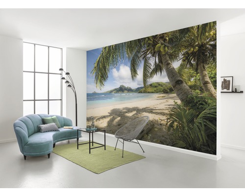 KOMAR Fotobehang vlies SHX9-126 Wanderlust - Stefan Hefele Beachoasis South Pacific 450x280 cm Woonkamer met fotobehang met strandmotief, bank, fauteuil en tapijt