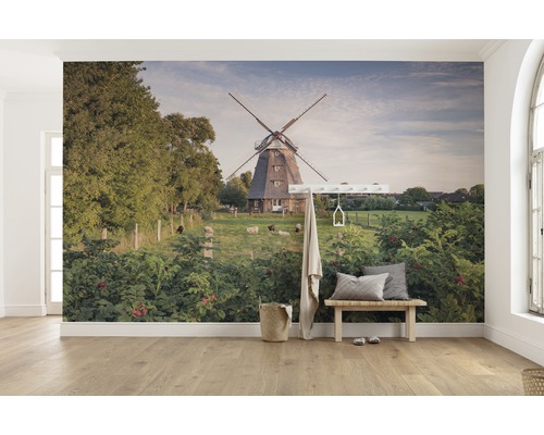 Wandafbeelding met een windmolen, schapen en weelderig groen in een lichte kamer.