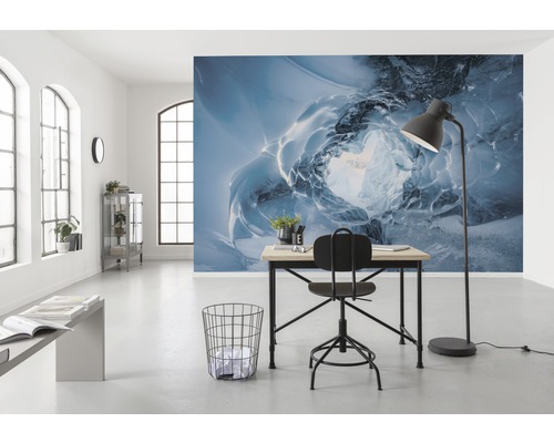 Een helder kantoor met een bureau, een stoel en fotobehang met een ijsgrotthema.