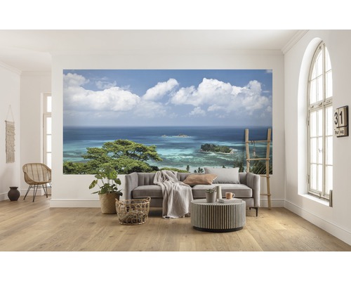Woonkamer met fotobehang van een kustpanorama met uitzicht op zee en een bewolkte hemel