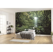 Lichte slaapkamer met fotobehang van een bos met waterval, bed met deken en nachtkastje
