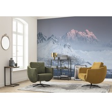 Woonkamer met fotobehang met bergmotief, twee draaifauteuils en een bijzettafel