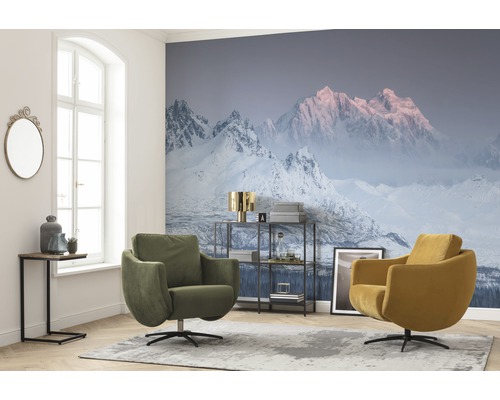 Woonkamer met fotobehang met bergmotief, twee draaifauteuils en een bijzettafel