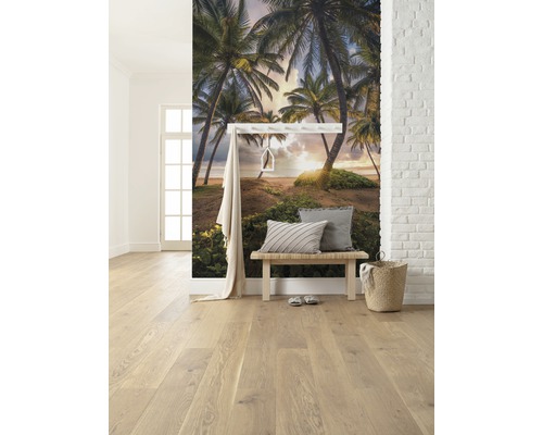 Lichte kamer met fotobehang van palmenstrand, bank en houten vloer