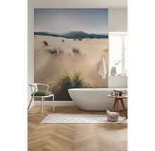 Moderne badkamer met bad, stoel, vloerkleed en fotobehang met duinmotief