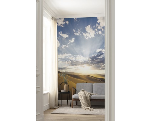 Woonkamer met fotobehang van een woestijnlandschap met hemel en wolken