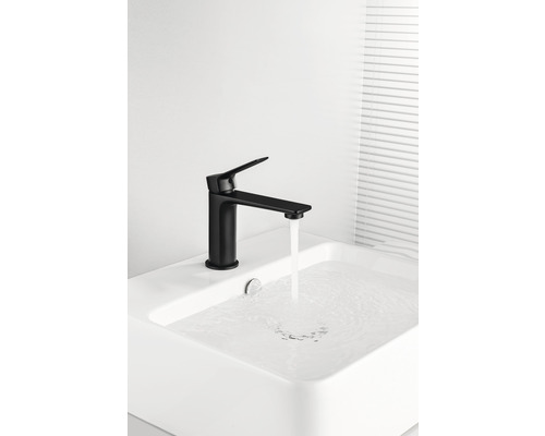 Zwarte wastafelkraan met stromend water in een wastafel.