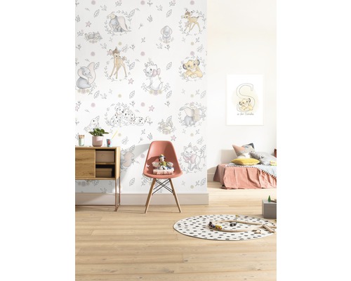 Kinderkamer met Disney behang met dierenmotieven, stoel en speelgoed.