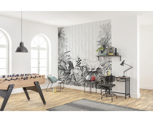 Lichte woonkamer met een fotobehang met jungle motieven, tafelvoetbal en bureau