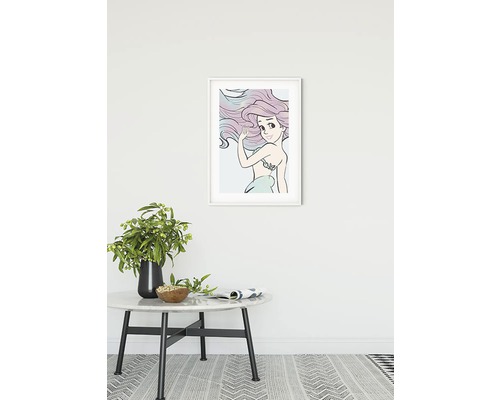 Ingelijste afbeelding van Ariël de kleine zeemeermin aan een muur boven een ronde tafel