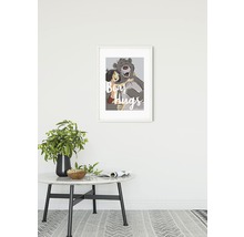 Ingelijste poster van een berenknuffel boven een bijzettafel met decoratie