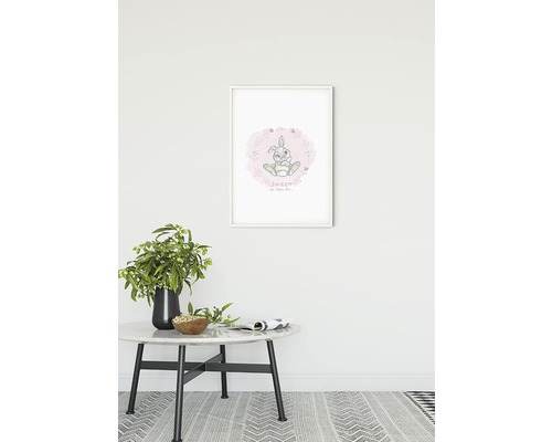 Ingelijste muurkunst met konijntjesmotief boven een tafel