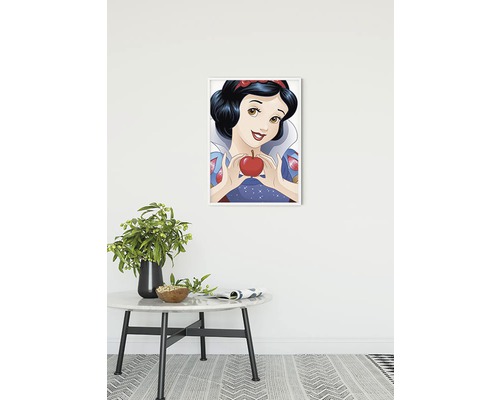 Ingelijste Sneeuwwitje poster met een appel in haar handen boven een tafel met potplant