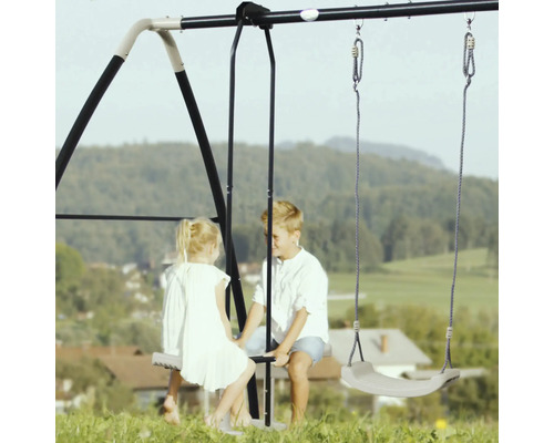 Dubbele schommel met twee kinderen in de tuin