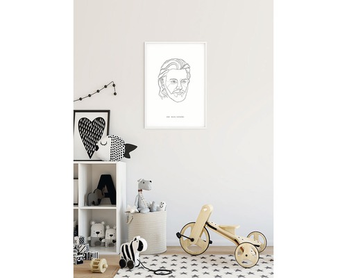 Kinderkamer met een ingelijst portret, een rek met speelgoed en een driewieler.