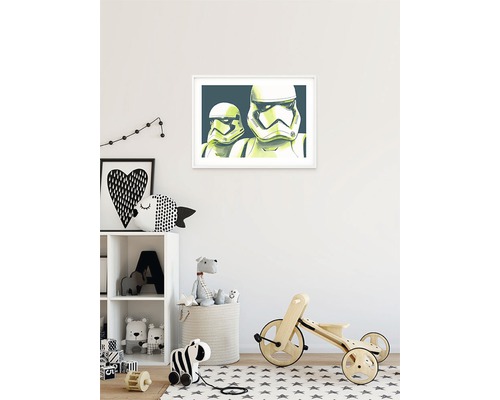 Kinderkamer met een ingelijste Star Wars afbeelding aan de muur, speelgoedrek en een houten fiets.