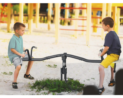 Twee kinderen spelen op een wip op een speelplaats.