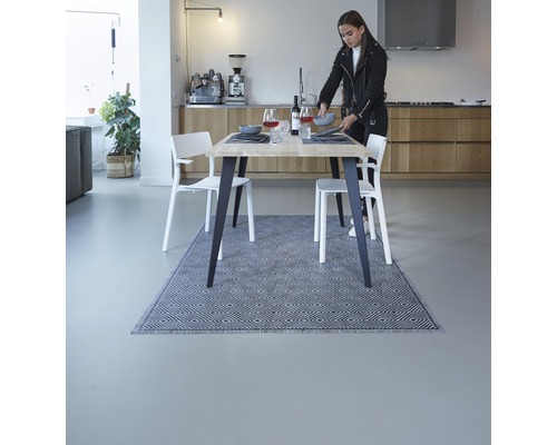 Eettafel met vloerkleed in een lichte eetkamer met stoelen en decoratie