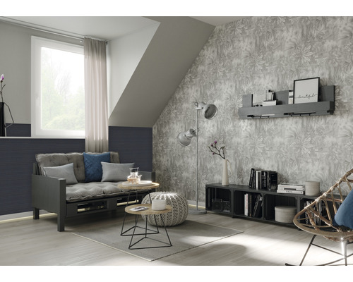 Woonkamer met slaapbank, bijzettafels, staande lamp en behang met motief