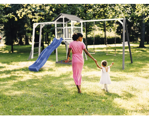 Speeltuin met glijbaan, speelhuis en schommel in de tuin