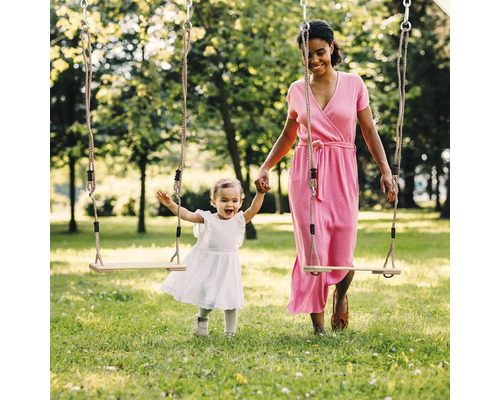 Moeder en dochter spelen op een houten schommel in het park.