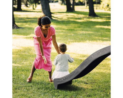 Moeder en kind met glijbaan in de tuin