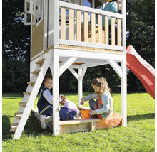 Speelhuis met glijbaan en zandbak met spelende kinderen in de tuin