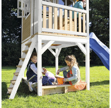 Speeltoren met glijbaan en zandbak met spelende kinderen in de tuin.