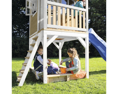Speeltoren met glijbaan en zandbak met spelende kinderen in de tuin.