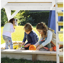 Kinderen spelen in de zandbak met dak op een speelplaats.